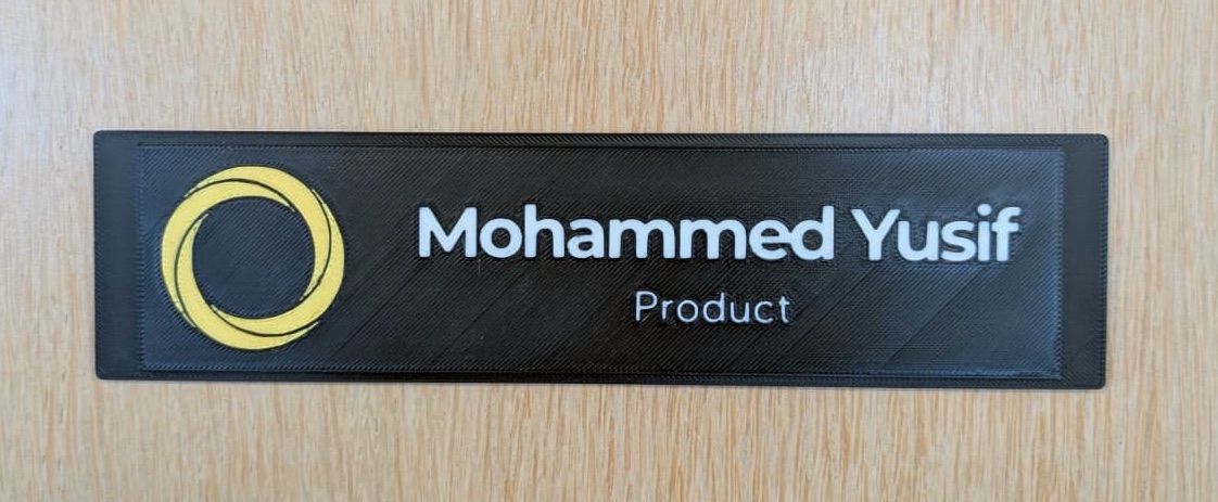 Printed black nameplate with a gold Nclusion mark and raised white text reading Mohammed Yusif, Product